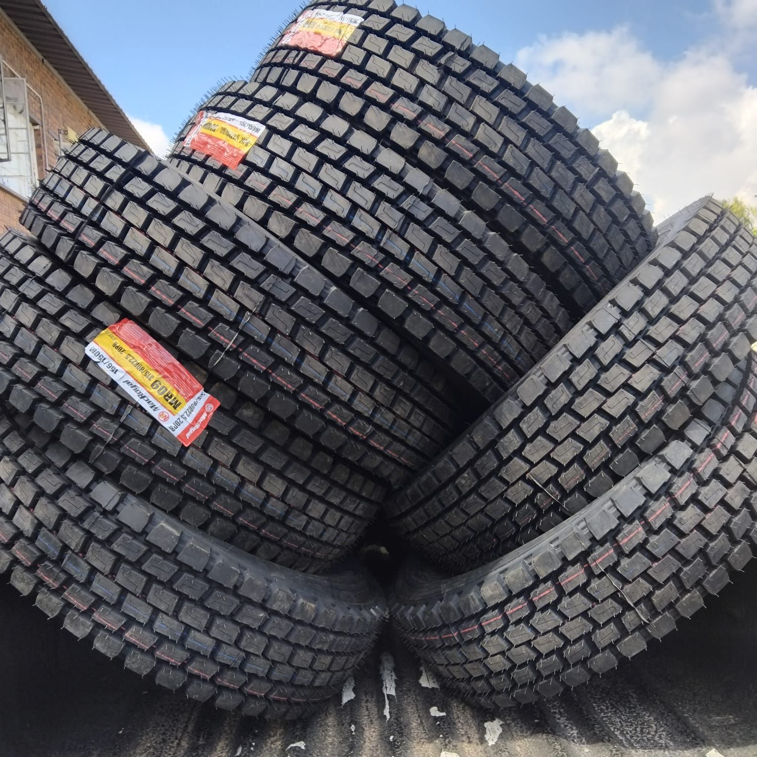 A stack of new 315/80R22.5 drive tyres with deep block tread